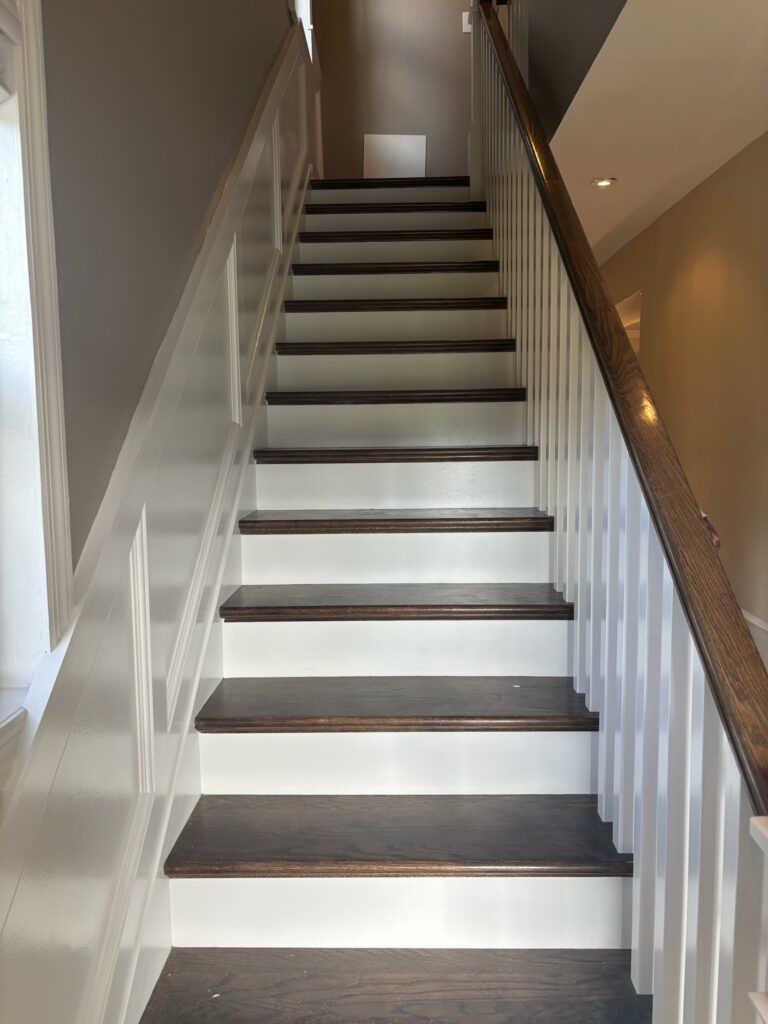 Same staircase finished, with crisp white risers and dark stained treads
