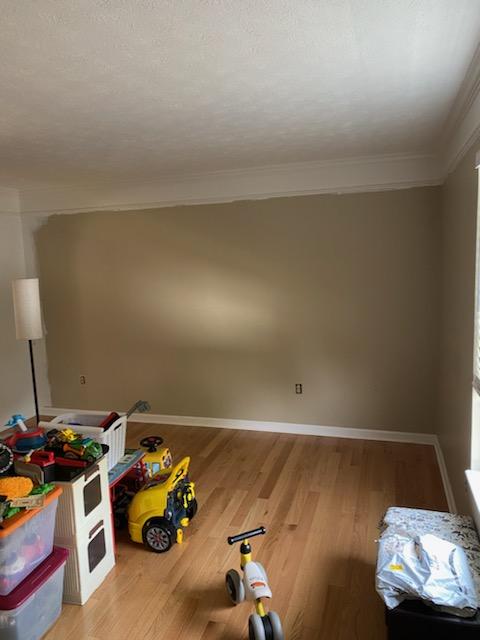 A playroom wall painted taupe halfway across, with the original lighter color still visible on the left